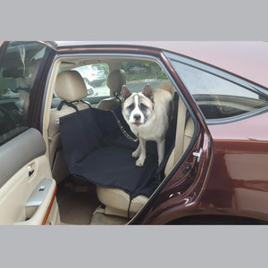the dog is sitting on black  car seat protector for dogs in the suv 